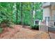 Backyard view showing patio, wooden deck with grill, and wooded area at 1850 Noblin Ridge Way, Duluth, GA 30097