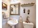 Charming powder room with a pedestal sink, decorative mirror, and safari themed artwork at 1850 Noblin Ridge Way, Duluth, GA 30097