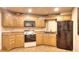 Kitchen area with wooden cabinets, stove, microwave, and black refrigerator at 1850 Noblin Ridge Way, Duluth, GA 30097