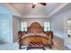 Main bedroom with a tray ceiling, fan, carpet and a decorative headboard and bed frame at 1850 Noblin Ridge Way, Duluth, GA 30097