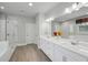 Well-lit bathroom features double sink vanity, glass shower, and wood-look tile flooring at 614 Denali Dr, Mableton, GA 30126