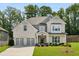 Charming two-story brick home featuring a three-car garage, manicured lawn, and mature landscaping at 614 Denali Dr, Mableton, GA 30126