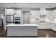Sleek kitchen with white cabinets, grey island, stainless steel appliances, and designer backsplash at 614 Denali Dr, Mableton, GA 30126
