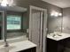 Bathroom showcases double sinks, dark wood cabinets, large mirrors, and a view of the soaking tub at 5415 Windcrest Ln, Suwanee, GA 30024
