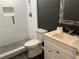 Bathroom showcasing a tile shower, a modern toilet, and a white vanity with a dark gray accent wall at 5415 Windcrest Ln, Suwanee, GA 30024