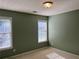 Bedroom featuring carpet, two windows with blinds, and neutral colored walls for a modern look at 5415 Windcrest Ln, Suwanee, GA 30024