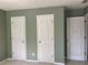 Bedroom featuring neutral walls and carpet with three white doors to closets or other rooms at 5415 Windcrest Ln, Suwanee, GA 30024