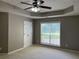 Bedroom features carpet floors, a large window, a ceiling fan, and a closet with white doors at 5415 Windcrest Ln, Suwanee, GA 30024