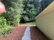 Long outdoor walk path with landscaped side yard, along the back of the home at 5415 Windcrest Ln, Suwanee, GA 30024