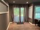 Living room featuring wood-look floors, recessed lights, and sliding glass doors with gray privacy curtains at 5415 Windcrest Ln, Suwanee, GA 30024
