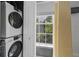 Bathroom featuring stackable washer and dryer and a window that allows for natural light in this convenient laundry space at 1154 Village Se Ct, Atlanta, GA 30316