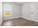 Bright bedroom with light gray walls, wood-look floors, a window, and white trim at 556 Paines Nw Ave, Atlanta, GA 30318