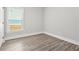This bedroom features light gray walls, wood-look floors, a window, and white trim at 556 Paines Nw Ave, Atlanta, GA 30318