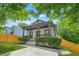 Lovely home showcasing a covered front porch with a ceiling fan, surrounded by mature landscaping and green lawn at 556 Paines Nw Ave, Atlanta, GA 30318