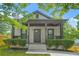 Quaint house featuring a covered front porch with ample seating and manicured shrubs along the walkway at 556 Paines Nw Ave, Atlanta, GA 30318