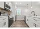 Modern kitchen with stainless steel appliances, sleek white cabinets, and quartz countertops at 556 Paines Nw Ave, Atlanta, GA 30318