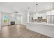 A spacious living room with wood floors, fireplace, and open access to a modern white kitchen with stainless appliances at 556 Paines Nw Ave, Atlanta, GA 30318