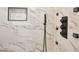 Modern shower with marble tiles, black hardware, and a built-in niche for toiletries at 556 Paines Nw Ave, Atlanta, GA 30318