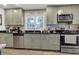 Kitchen features stainless appliances, tile backsplash, granite counters, and green cabinets at 111 Marona Street Ne Ne St, Atlanta, GA 30307