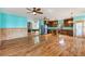 Open concept living space leads to a kitchen and game room, featuring wood floors and turquoise walls at 3192 Highway 411 Ne, White, GA 30184