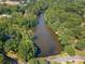A picturesque aerial view of a community lake surrounded by lush green trees and beautiful homes at 3436 Laurelwood Ne Ct, Roswell, GA 30075