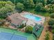 An aerial view of a community pool, tennis court and playground area surrounded by lush greenery at 3436 Laurelwood Ne Ct, Roswell, GA 30075