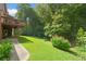 Manicured lawn extending to wooded area, complemented by a charming patio and lush foliage at 3436 Laurelwood Ne Ct, Roswell, GA 30075