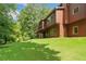 Well-manicured backyard featuring a grassy lawn, mature trees, and an elevated deck at 3436 Laurelwood Ne Ct, Roswell, GA 30075
