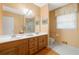 Bright bathroom with dual sinks, tiled floor, framed mirror and peach painted walls at 3436 Laurelwood Ne Ct, Roswell, GA 30075