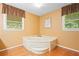 Bathroom showcasing a corner tub with a bright window, perfect for relaxation at 3436 Laurelwood Ne Ct, Roswell, GA 30075