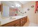 Spacious bathroom with double sinks, a large mirror, and charming wallpaper at 3436 Laurelwood Ne Ct, Roswell, GA 30075