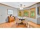Cozy eat-in kitchen featuring wood floors, large windows, wood trim and four upholstered chairs at 3436 Laurelwood Ne Ct, Roswell, GA 30075