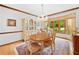 Light-filled dining room with a chandelier, large bay window, and a decorative area rug at 3436 Laurelwood Ne Ct, Roswell, GA 30075