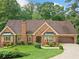 Charming brick home with mature landscaping, a two-car garage, and a welcoming entrance at 3436 Laurelwood Ne Ct, Roswell, GA 30075