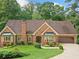 Charming brick home featuring bay windows, attached garage, and lush lawn at 3436 Laurelwood Ne Ct, Roswell, GA 30075