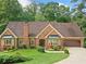 Charming single-Gathering brick home with an attached garage, well-maintained lawn, and mature landscaping at 3436 Laurelwood Ne Ct, Roswell, GA 30075