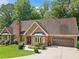 Brick home with large bay windows, attached garage, and well-manicured lawn at 3436 Laurelwood Ne Ct, Roswell, GA 30075