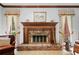 A classic fireplace with brick surround and mantle flanked by two windows with ornate curtains at 3436 Laurelwood Ne Ct, Roswell, GA 30075