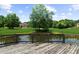 View from the deck overlooking the expansive backyard, a pond, and an impressive home with lush landscaping at 932 Shadowford Fls, Lithonia, GA 30058