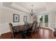 Dining room with hardwood floors, tray ceiling, chandelier, and large windows offering natural light at 932 Shadowford Fls, Lithonia, GA 30058