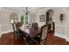 Dining room with dark wood table and chairs, crown molding, hardwood floors, and elegant décor at 932 Shadowford Fls, Lithonia, GA 30058