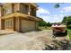 Two-story home with a Mediterranean-style exterior, a well-manicured lawn, a three-car garage, and ample parking space at 932 Shadowford Fls, Lithonia, GA 30058