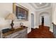 View of hallway featuring hardwood floors, an arched entryway, and a decorative table with a vintage lamp at 932 Shadowford Fls, Lithonia, GA 30058