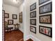 View of a hallway featuring wood floors and a diverse gallery of framed artworks and historic black & white photos at 932 Shadowford Fls, Lithonia, GA 30058