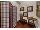 Hallway with hardwood floors, screen, antique chair, and an accent table decorated with framed artwork at 932 Shadowford Fls, Lithonia, GA 30058