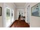 Hallway with double doors leading to the outside and dark hardwood floors offering a warm welcome at 932 Shadowford Fls, Lithonia, GA 30058