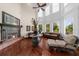 Bright living room featuring a fireplace, tall windows, hardwood floors, and comfortable leather furnishings at 932 Shadowford Fls, Lithonia, GA 30058