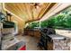This covered outdoor kitchen features brick counter tops, stainless steel appliances and backyard views at 932 Shadowford Fls, Lithonia, GA 30058