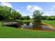 A peaceful pond view with a wooden dock surrounded by trees in a serene backyard setting at 932 Shadowford Fls, Lithonia, GA 30058