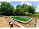 Outdoor view of the pool under construction in backyard surrounded by trees and greenery at 932 Shadowford Fls, Lithonia, GA 30058